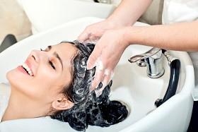 Young woman washing hair in salon